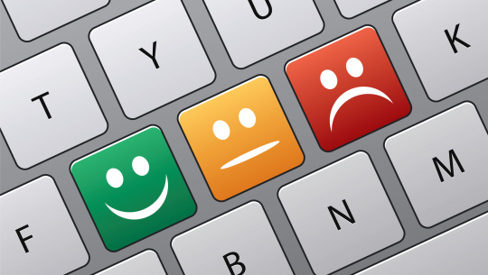 Smiley, ambivalent, and frowny faces as keys on a keyboard.